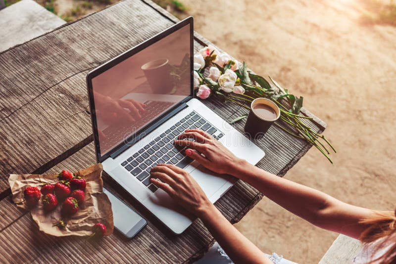 Workspace z dziewczyn rękami, laptop, bukiet peonie kwitnie, kawa, truskawki zdjęcia stock Workspace z dziewczyn rękami, laptop, bukiet peonie kwitnie, kawa, truskawki zdjęcia stock