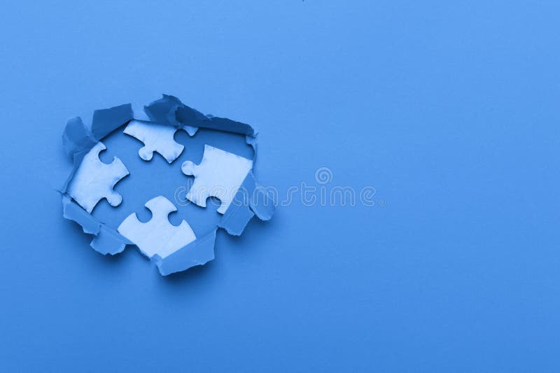 World Autism Awareness, concept with puzzle or jigsaw pattern in paper cut hole. Blue background