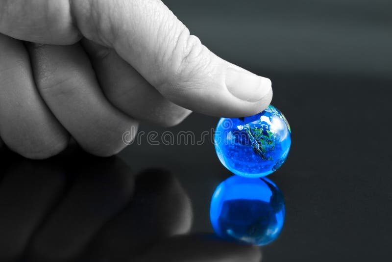 The World - Under my Thumb. Thumb Pressing Down on Bright Blue Marble Globe stock photo The World - Under my Thumb. Thumb Pressing Down on Bright Blue Marble Globe stock photo