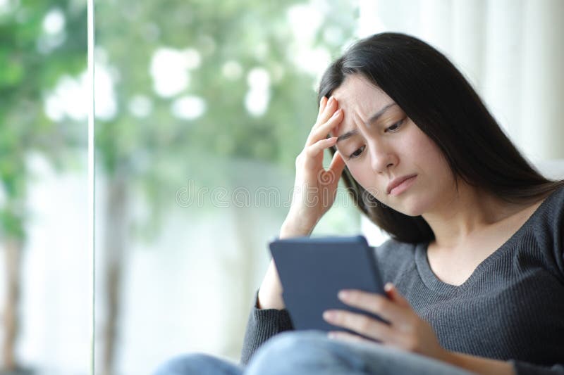 Worried asian woman reading ebook at home stock photos