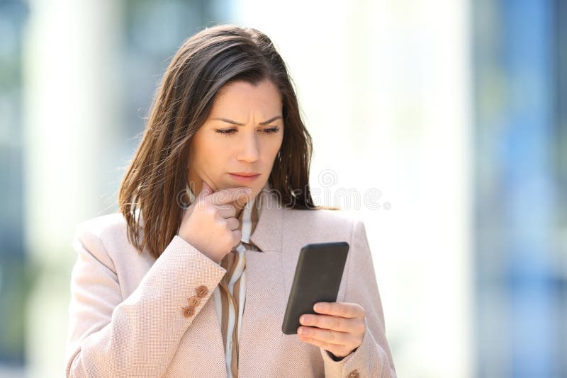 Worried businesswoman reading message on phone royalty free stock photography
