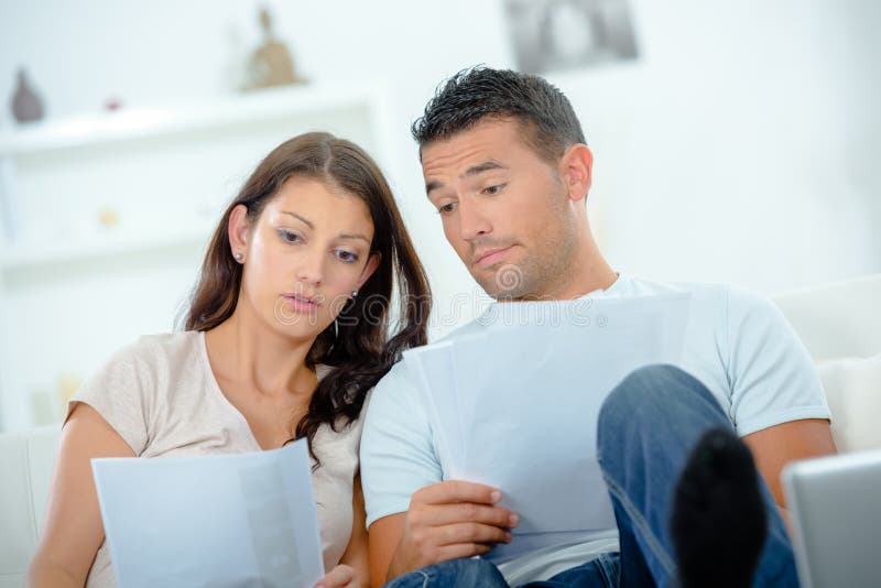 Worried couple after calculating bills sitting at home stock photo Worried couple after calculating bills sitting at home stock photo