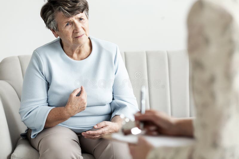 Worried grandmother talking to a financial advisor about her deb stock image Worried grandmother talking to a financial advisor about her deb stock image