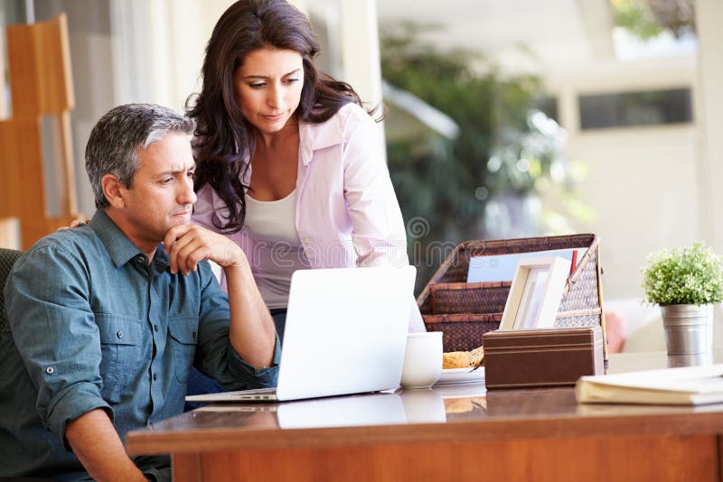Worried Hispanic Couple Using Laptop On Desk At Home stock image Worried Hispanic Couple Using Laptop On Desk At Home stock image