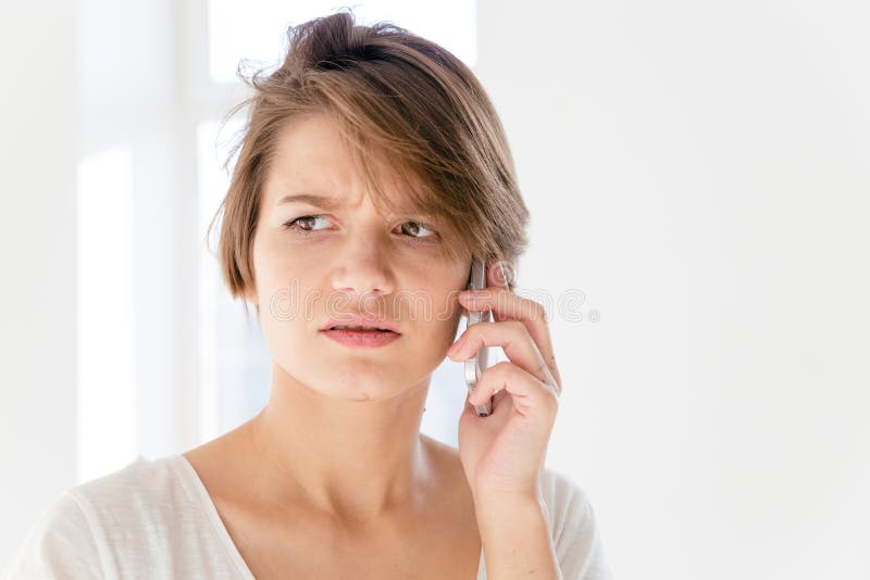 Worried perturbou a jovem mulher que fala no telefone celular foto de stock royalty free Worried perturbou a jovem mulher que fala no telefone celular foto de stock royalty free