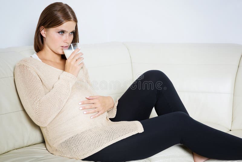 Worried pregnant woman drinking milk stock photo Worried pregnant woman drinking milk stock photo