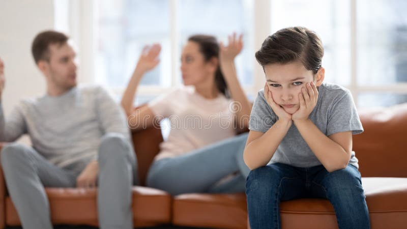 Worried upset small son hurt by parents conflict. stock photography Worried upset small son hurt by parents conflict. stock photography