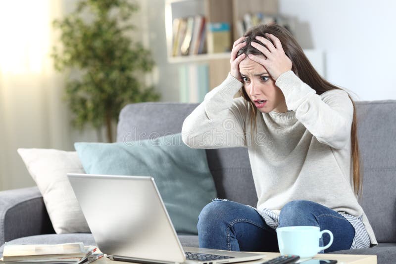 Worried woman checking laptop content at home