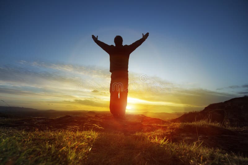 Worship and praise. Silhouette of a man with hands raised in the sunset concept for religion, worship, prayer and praise Worship and praise. Silhouette of a man with hands raised in the sunset concept for religion, worship, prayer and praise