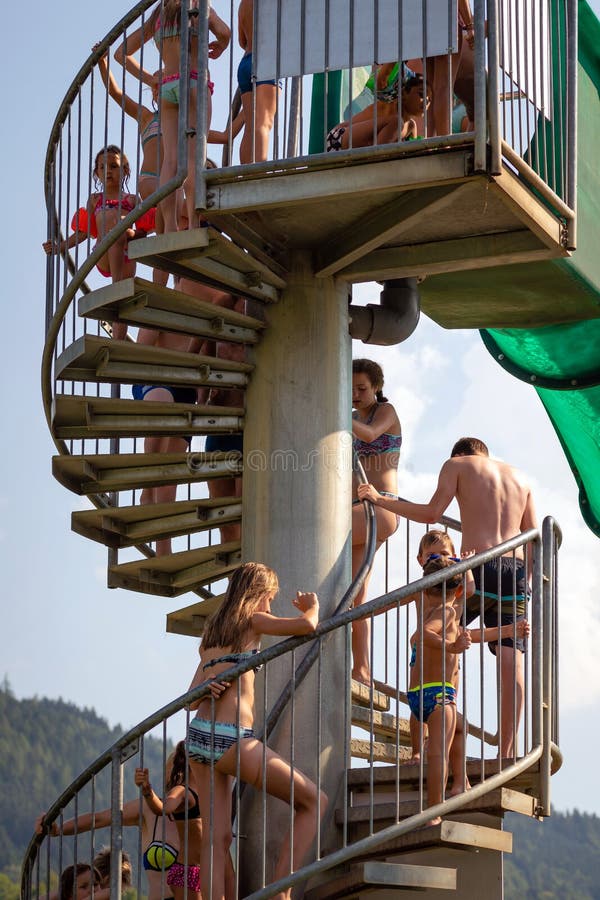 WORTHERSEE, ÖSTERREICH - 7. AUGUST 2018: Leute, welche die Leiter zum Wasserpark-Diaanfang klettern stockfotografie WORTHERSEE, ÖSTERREICH - 7. AUGUST 2018: Leute, welche die Leiter zum Wasserpark-Diaanfang klettern stockfotografie