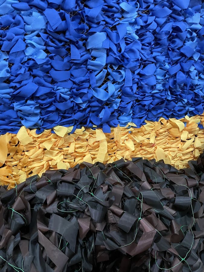 Woven scrim in the colors of the national flag of Ukraine. Blue and yellow colours. And military camouflage scrim. Close up detail stock image