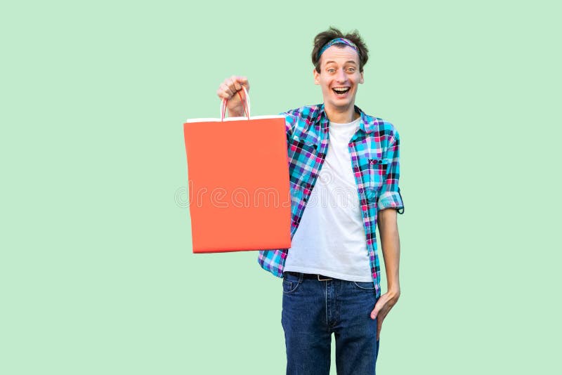 Wow! Giovane uomo adulto moderno colpito dei pantaloni a vita bassa in maglietta bianca e condizione a quadretti della camicia e fotografia stock libera da diritti Wow! Giovane uomo adulto moderno colpito dei pantaloni a vita bassa in maglietta bianca e condizione a quadretti della camicia e fotografia stock libera da diritti