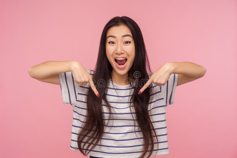 Wow look at advertise! Portrait of excited, surprised girl in striped t-shirt pointing down and looking with shocked face