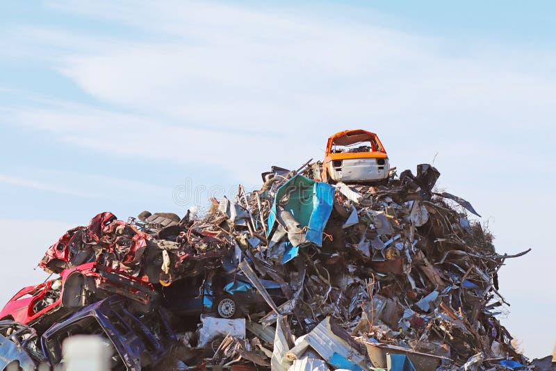 The wreck of a retro car Fiat 126p Polish production on top of a mountain of metal scrap. Disposal of old and broken cars. Landfil. L transport. He climbed to stock image The wreck of a retro car Fiat 126p Polish production on top of a mountain of metal scrap. Disposal of old and broken cars. Landfil. L transport. He climbed to stock image