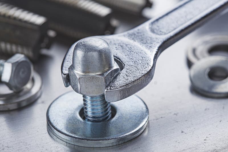 Wrench Tightens Steel Cap Nut in Steel Billet. Spanner, Bolt, and Nuts