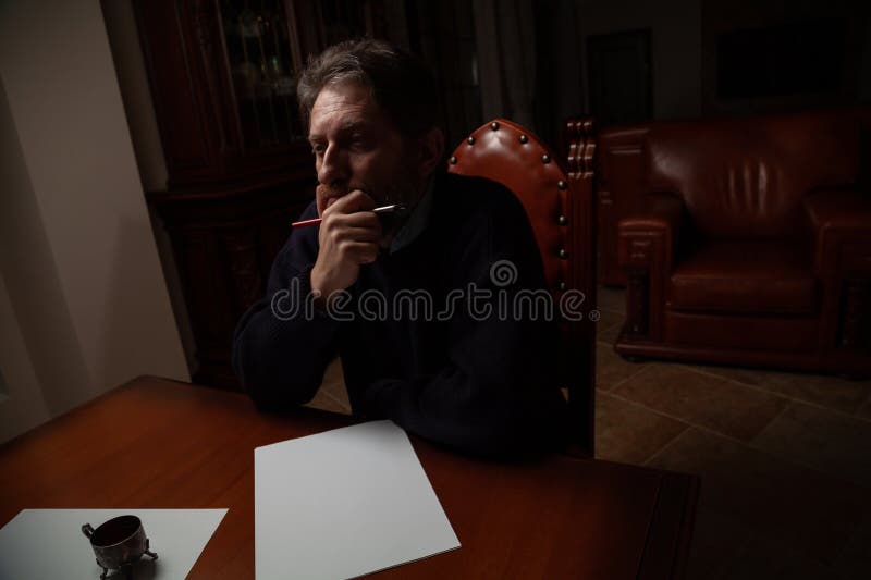 Writer with beard thinks over white sheet royalty free stock images