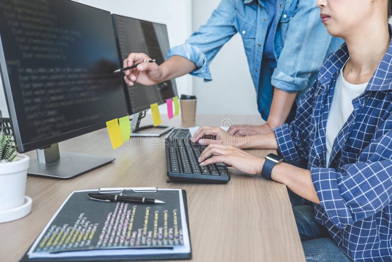 Writing codes and typing data code technology, Two professional programmer cooperating working on web site project in a software developing on desktop computer at company. Coding program data stock images, royalty-free photos and pictures