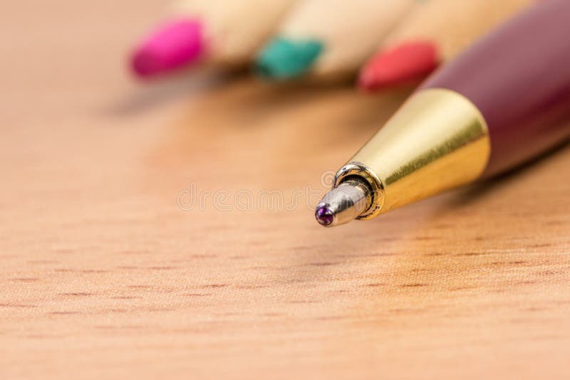 Writing Pen Stands Out Against The Background Of Colored Pencils