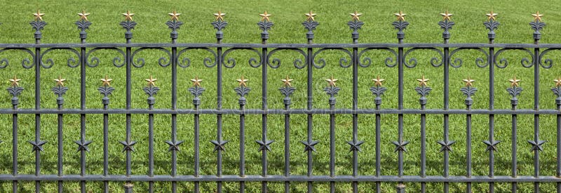 Wrought iron fence with gold stars surounding the state capitol in Austin, Texas. 2 pictures were used to produce this a larger panoramic image