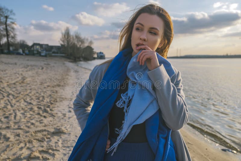 Wspaniała europejska kobieta w ciepłym żakiecie i sukni na spacerze w parkowej pobliskiej rzece wietrznie pogody Ona odzieżowa ko obraz royalty free Wspaniała europejska kobieta w ciepłym żakiecie i sukni na spacerze w parkowej pobliskiej rzece wietrznie pogody Ona odzieżowa ko obraz royalty free