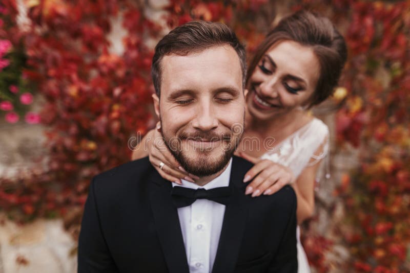 Wspaniała panna młoda delikatnie ściska eleganckiego fornala przy starą ścianą autum obrazy stock Wspaniała panna młoda delikatnie ściska eleganckiego fornala przy starą ścianą autum obrazy stock