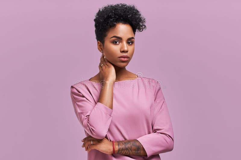 Wspaniały zmrok skinned młodej kobiety z Afro fryzurą i ufnym spojrzeniem, pozy dla modnego magazynu, spojrzenia na boku zdjęcia royalty free Wspaniały zmrok skinned młodej kobiety z Afro fryzurą i ufnym spojrzeniem, pozy dla modnego magazynu, spojrzenia na boku zdjęcia royalty free