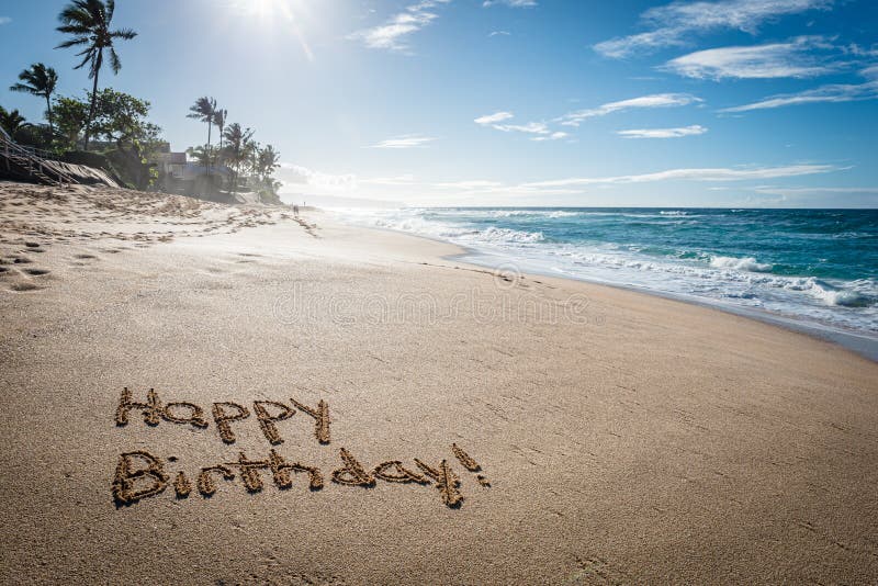 Happy Birthday written in the sand on Sunset Beach in Hawaii with palm trees and the ocean in the background. Happy Birthday written in the sand on Sunset Beach in Hawaii with palm trees and the ocean in the background