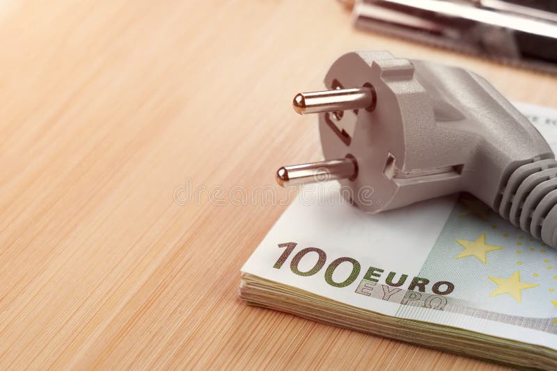Wtyczka elektryczna na stercie europejskich banknotów euro. koncepcji efektywnego zużycia energii elektrycznej obrazy royalty free