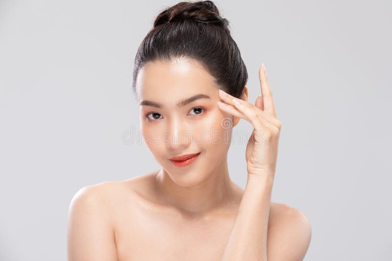 Wunderschöne asiatische Frau, die sich ein Kameralächeln anschaut, mit sauberer und frischer Haut glücklich und fröhlich mit posit stockfotografie