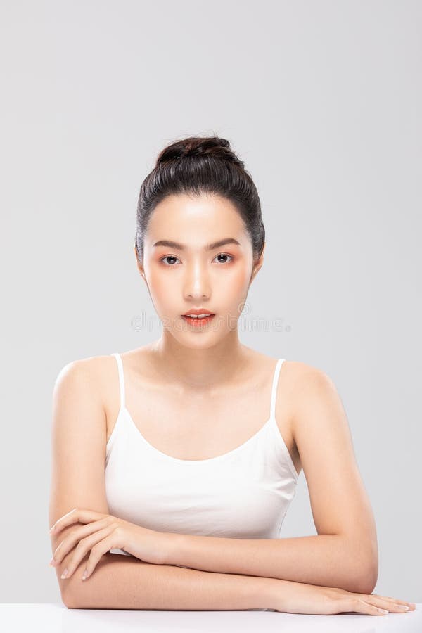 Wunderschöne asiatische Frau, die sich ein Kameralächeln anschaut, mit sauberer und frischer Haut glücklich und fröhlich mit posit lizenzfreie stockbilder