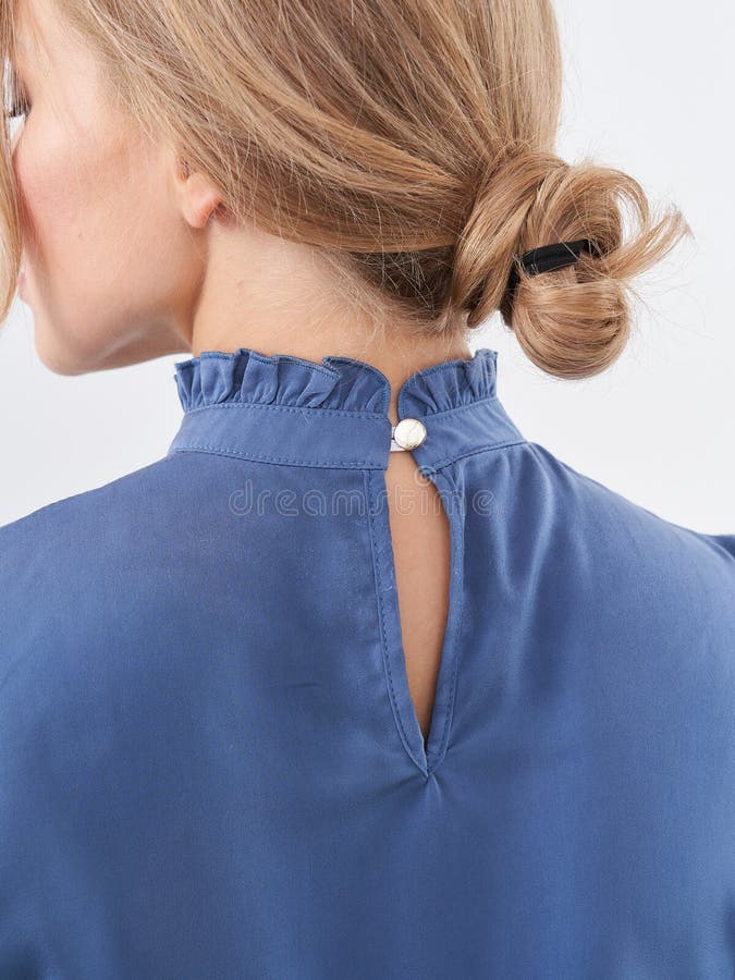 Wunderschönes blondes Modell, das eine stilvolle blaue Bluse in einer fröhlichen Inneneinrichtung zeigt lizenzfreies stockbild