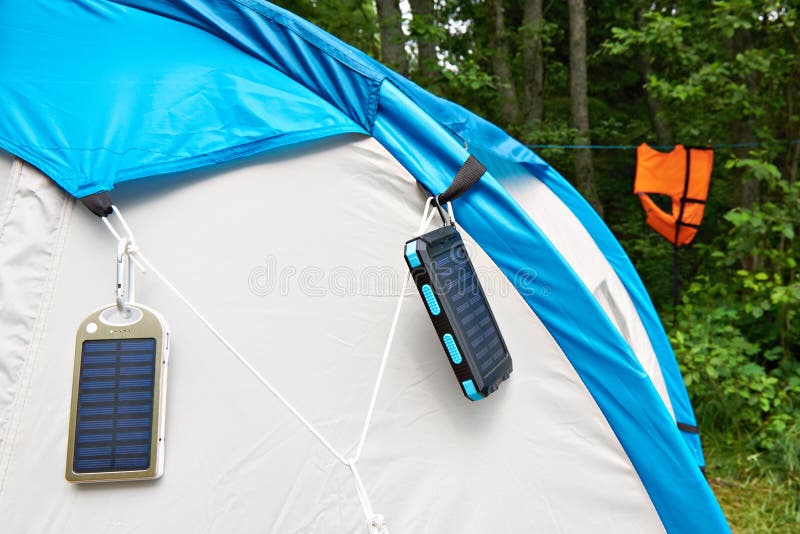 Hiking hand-held portable batteries with solar panels on tent. Hiking hand-held portable batteries with solar panels on tent