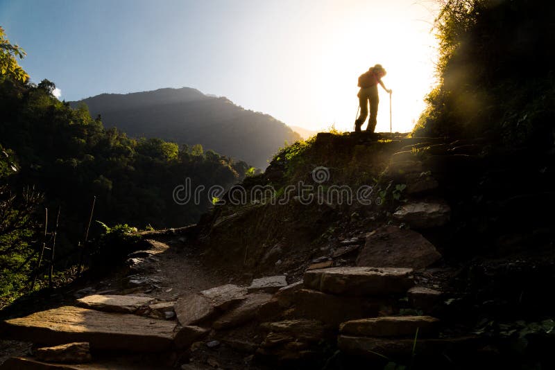 Hiker in silhouette hiking at highland towards sunrise. Lens flare intended. Hiker in silhouette hiking at highland towards sunrise. Lens flare intended.