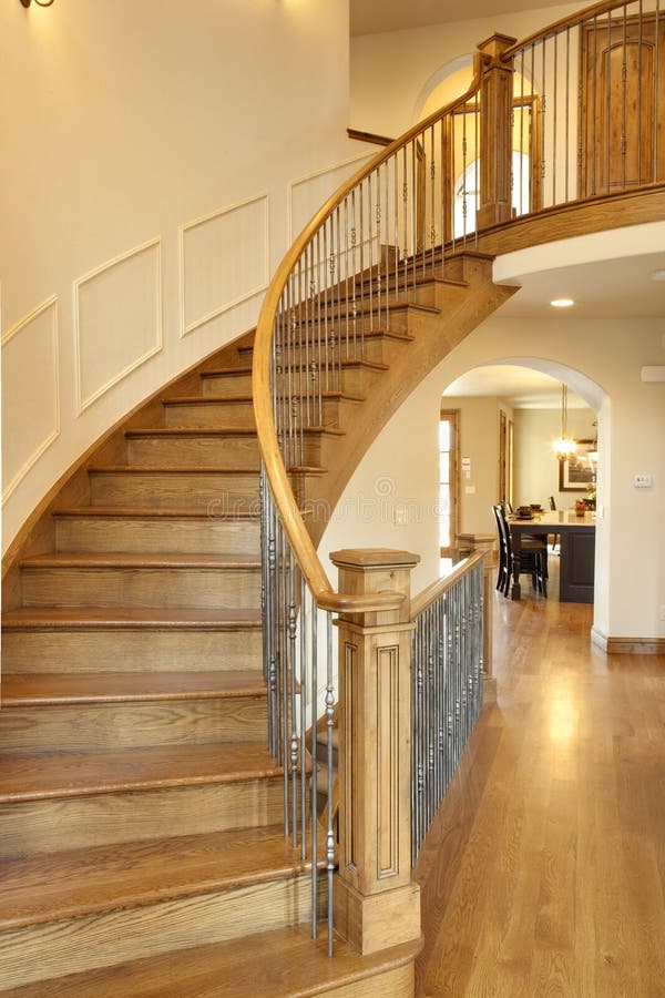All wood curved staircase with hallway and kitchen in view. All wood curved staircase with hallway and kitchen in view.