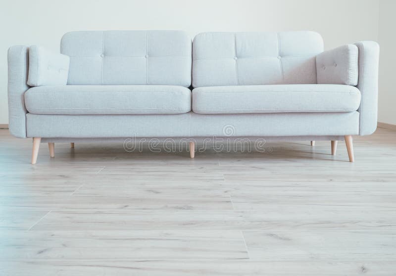 Wygodna współczesna scandinavian stylu kanapa na dębowej laminat podłoga obraz stock Wygodna współczesna scandinavian stylu kanapa na dębowej laminat podłoga obraz stock