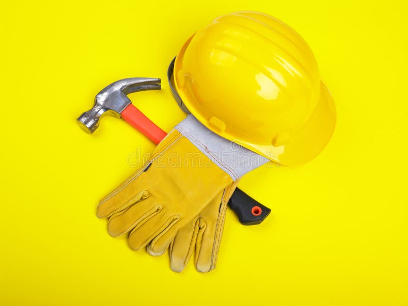 Worker equipment - HardHat Hammer And Gloves on yellow. Worker equipment - HardHat Hammer And Gloves on yellow