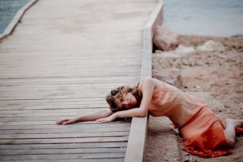 Sad girl lying on berth at sea coast. Sad girl lying on berth at sea coast