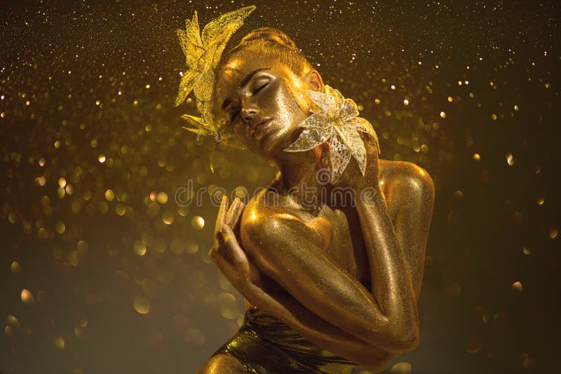 Wysoka moda złota modelka kobieta z jasnymi złotymi błyskami na skórze fantasy kwiat portret pięknej dziewczyny świecący makijaż