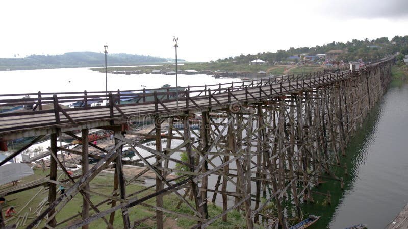Wysoki drewniany most z tratwy wioską na dużej jeziornej pobliskiej granicie Tajlandia i Myanmar,. Tratwy wioska na dużej jeziornej pobliskiej granicie, wysoki drewniany most, z bambusa mosta spławową grzywą wieśniakiem, i, ptasiego oka widoku strzał