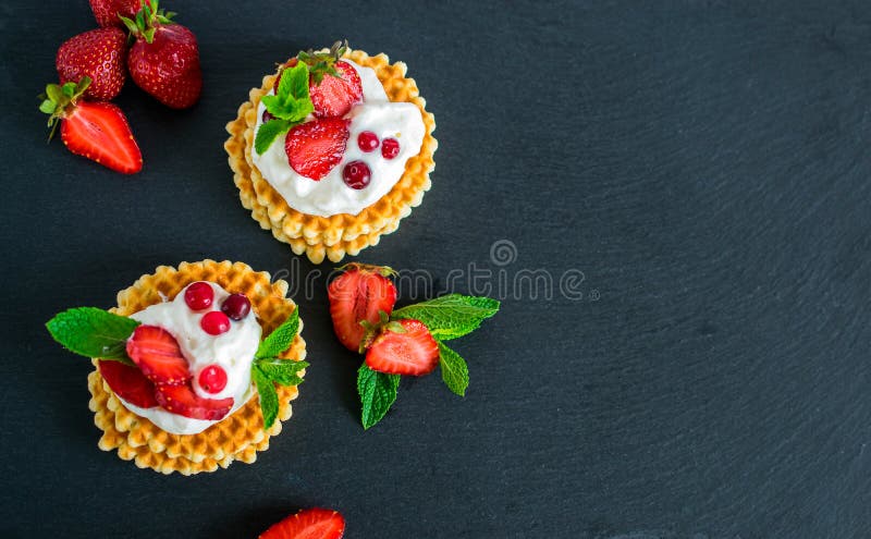 Wy?mienicie crispy belgijscy gofry z bato?y? truskawkami i ?mietank? zdjęcie stock Wy?mienicie crispy belgijscy gofry z bato?y? truskawkami i ?mietank? zdjęcie stock