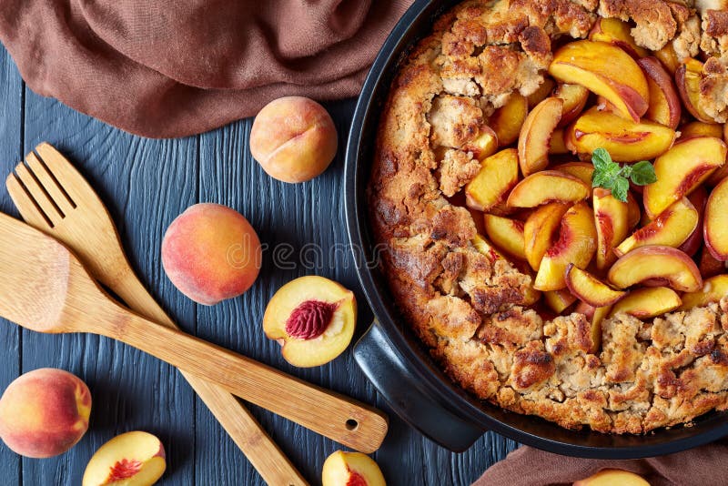 Delicious and mildly sweet Peach Cobbler in a black baking dish, view from above, flat lay. Delicious and mildly sweet Peach Cobbler in a black baking dish, view from above, flat lay