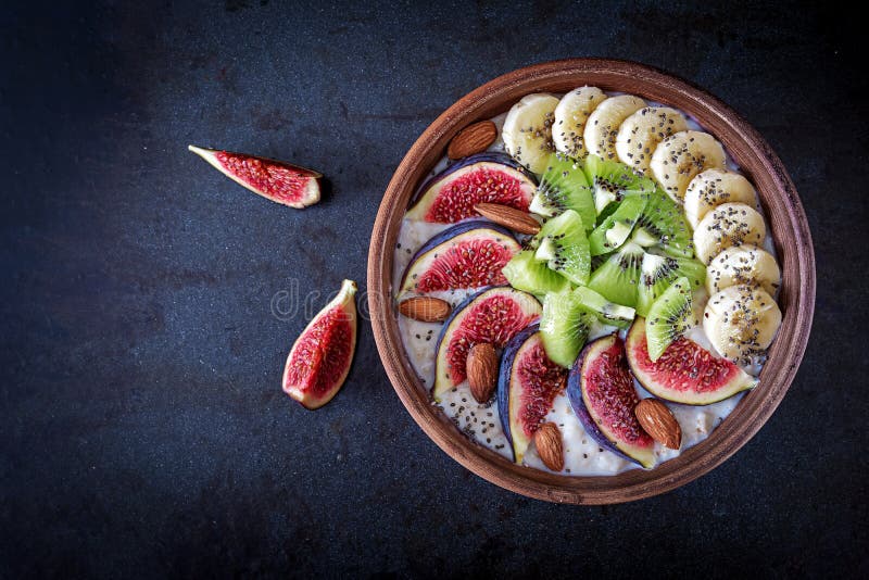 Wyśmienicie i zdrowy oatmeal z fig, kiwi, banana, migdału i chia ziarnami obrazy stock