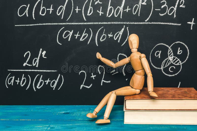 Wzory matematyczne na tablicy i drewnianym człowieku obrazy royalty free