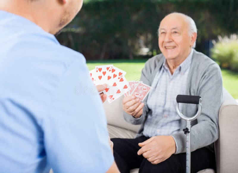 Wärter-und älterer Mann-Spielkarten an der Krankenpflege