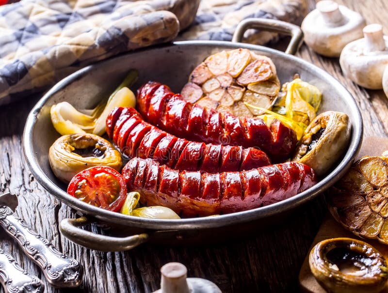 Würste Grillwürste Gegrillte Wurst mit Pilzknoblauchtomaten und -zwiebeln lizenzfreie stockfotos Würste Grillwürste Gegrillte Wurst mit Pilzknoblauchtomaten und -zwiebeln lizenzfreie stockfotos