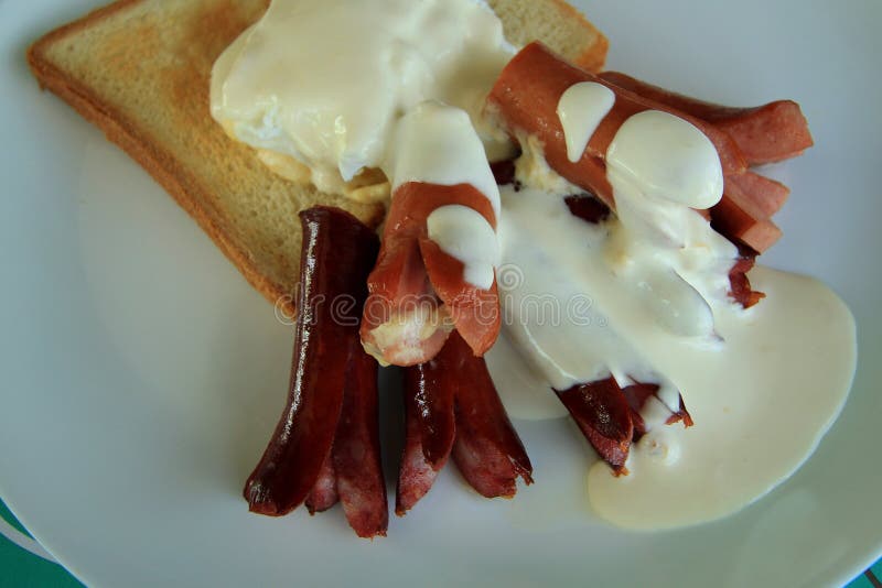 Fried frankfurters, shirred eggs and wheat toast served for breakfast. Fried frankfurters, shirred eggs and wheat toast served for breakfast