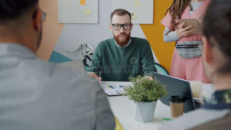 Wütender junger Mann, der an den Beschäftigten für enttäuschende Arbeitsergebnisse im Büro schreit.