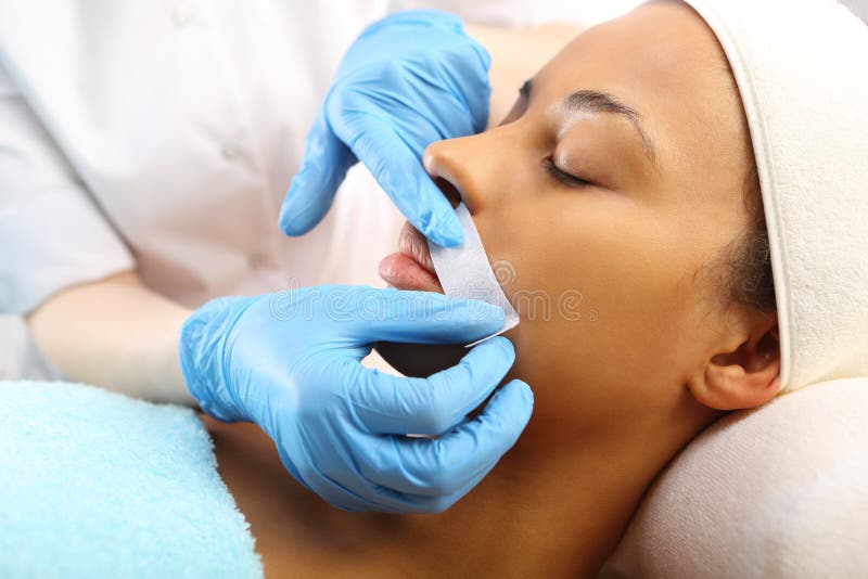 Woman in a beauty salon waxing during surgery. Woman in a beauty salon waxing during surgery