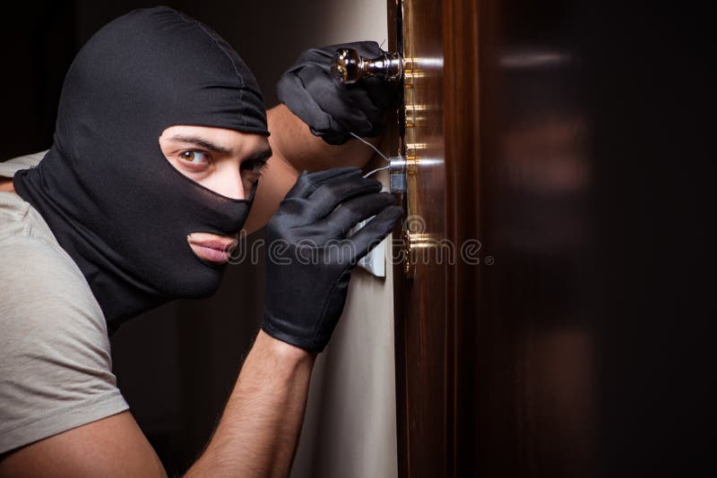 Włamywacz jest ubranym balaclava maskę przy miejscem przestępstwa