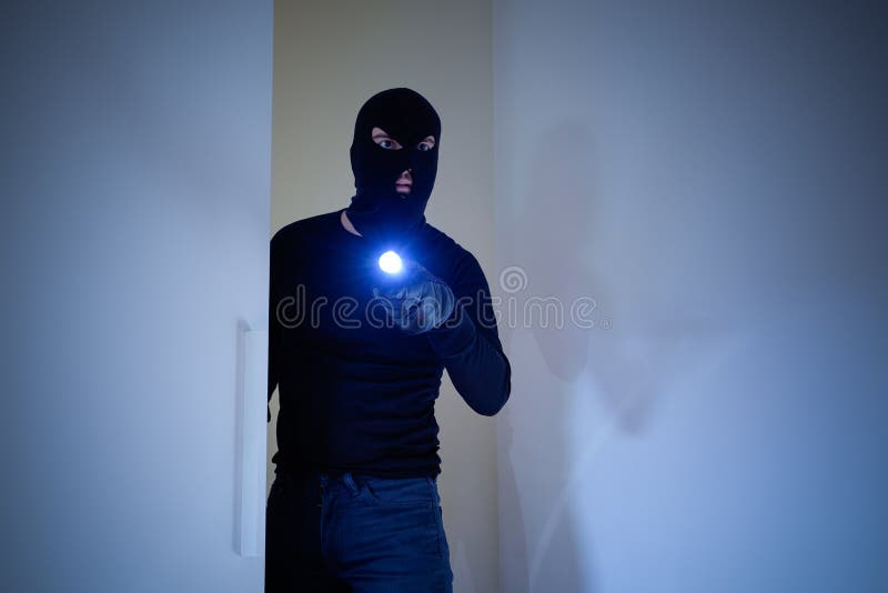Włamywacz jest ubranym balaclava trzyma latarkę zdjęcia royalty free